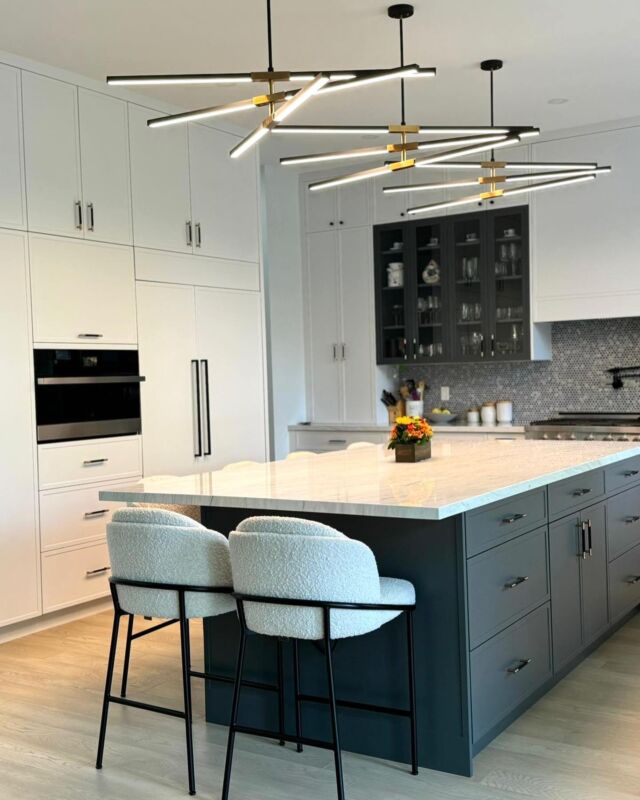 The grey-painted modern kitchen, with its sleek lines and minimalist design, provides a cozy contrast to the warm hues of autumn leaves visible just outside the window. #modernkitchen #kitchentoronto #customkitchens #customcabinetry #modernkitchen #custombuilt